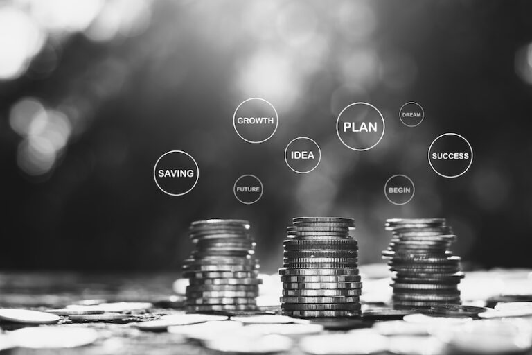 Myntstaplar med text ovanför, sparande, idé, investering osv. Symboliserar fondsparande.